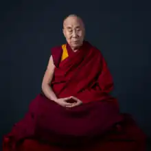 The Dalai Lama seated in the lotus position with his eyes closed