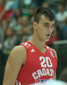 Chest high view of man with short dark hair wearing a red Croatia uniform