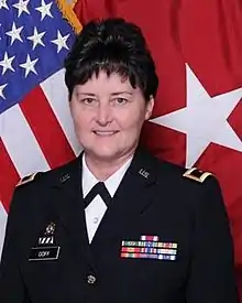 Image of Darlene Goff in uniform in front of an American flag, professional portrait