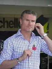 David Coulthard wearing a checkered T-shirt preparing for a media broadcast