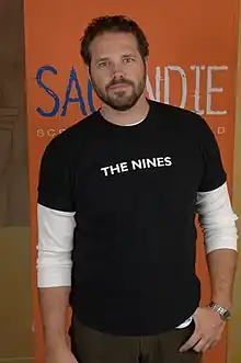 A brown-haired man wearing a black shirt