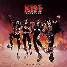 The 4 members of Kiss in a fiery background displaying fire and smoke.