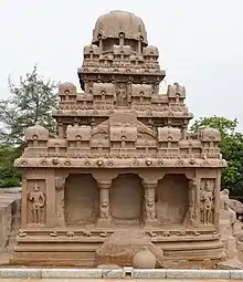 Stone temple, with rocks in front and another temple on the left