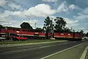 44238 & 4470 haul a northbound goods train cross Beaudesert Road, Acacia Ridge, 1987. This crossing has since been replaced by an overpass