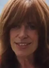 The face of a middle-aged white woman with long reddish hair