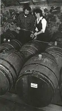 Dick and Nancy Ponzi stand in a room of wine barrels.