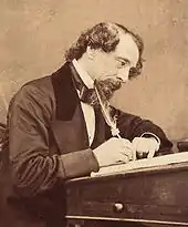 Sepia-tone image of the profile of a man in 1860-era clothes at work at a writing desk, using a quill