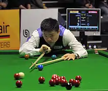 Ding playing a shot with the rest
