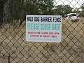 Dingo Barrier fence sign, near Bell, Queensland, Australia. Sign on gate for stock adjacent to cattle grid. 2018