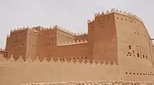 Earthen colored building with small windows.