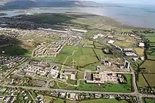 Aerial view of the area with buildings,houses, open lands and on windmill. The Irish Sea is on top right hand corner. There is another island visible on top left hand corner