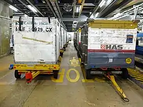 Those on the left are dollies from Cathay Pacific for baggage unit load devices (ULDs). Those on the right are dollies for loose baggage.