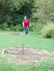 A person playing horseshoes