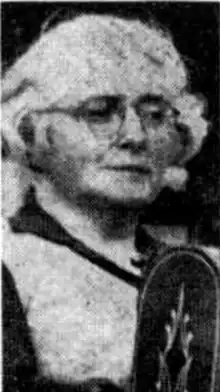 A grainy photograph of an older white woman with white hair, wearing glasses.