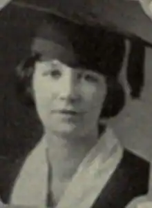 A young white woman wearing academic cap and gown