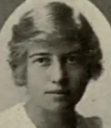 A young white woman with blonde hair combed in a side-parted style
