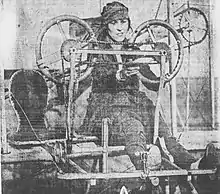 B&W photo of a woman flying an early plane