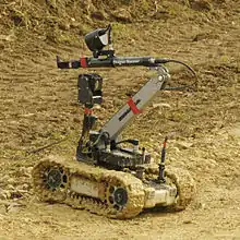 A small tracked robot in a sandy area