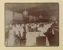 Black and white photo of a large room with decorated dining tables