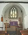 Chancel of St. Leonard & St. Catherine's parish church, showing late 12th-century chancel arch and 1894 east window by Comper & Bucknall