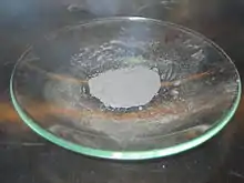 Light-gray powder on a glass dish