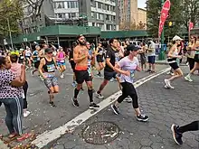 Group of runners with spectators in the foreground.