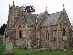 Stone building with square tower and arched windows.