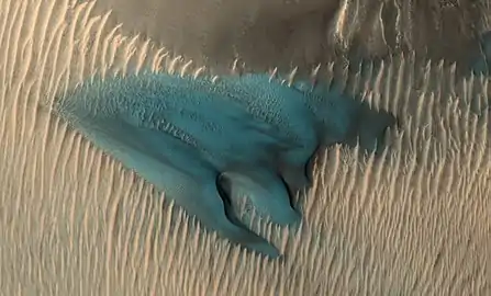A dune on Mars appears in false colors blue. In false colour colours yellow to blue represent warmer to colder soil