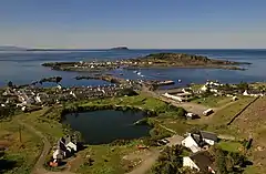 The flooded quarry and village of Ellenabeich with the outline of the former island of Eilean-a-beithich at centre left and Easdale beyond