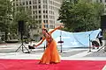 Uyghur woman dancing in front of the flag in Washington D.C.