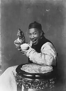 In the late 19th century and early 20th century, photographs taken in the United Kingdom rarely depicted people smiling, in accordance with the cultural conventions of Victorian and Edwardian society. In contrast, the photograph Eating Rice, China depicts a smiling Chinese man.
