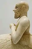 A profile of the statue showing the seated posture and the kaunakes skirt