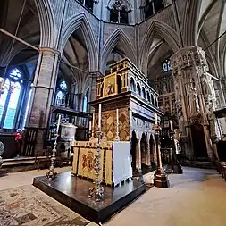 A large, elaborately-decorated tomb with an altar in front.