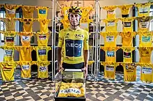Egan Bernal in 2019, in front of an assortment yellow jerseys of the museum.