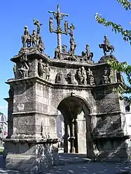 On the buttress on the left we see the pietà with the small sculpture depicting the Holy Trinity above it. On the corniche and from left to right we see Jesus being mocked and a blindfold put round his eyes, then Peter kneeling before a rock, followed by Jesus being flogged by three guards and finally the Crown of thorns being forced down on Jesus' head. On the upper platform we see Jesus emerging from his tomb in the centre and can see some of the seven statues of cavaliers spread over the calvary platform.