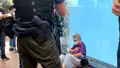 An elderly woman showing signs of discomfort after being stopped and searched by police