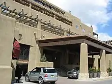 A brown building with an awning that says "EL DORADO" on it. The boxy brown rooms look like they are made from clay.