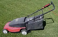 Corded rotary lawn mower, with rear grass catcher (note the red cord attached at the handle)