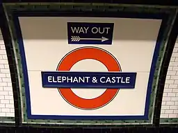 A London Underground "roundel" reads "Elephant and Castle." A smaller sign says "Way Out" above it.