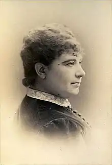A middle-aged white woman's head and shoulders, in a sepia-toned portrait.