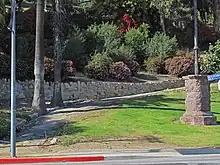 Picture of the entrance to Elysian Park with path, stone wall, and sidewalk