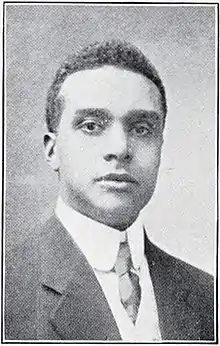 Black and white photograph from the bust up of a man in a suit and tie