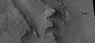 Layers in depression in crater, as seen by HiRISE under HiWish program A special type of sand ripple called Transverse aeolian ridges, TAR's are visible and labeled.  Location is Hellas Planitia in Noachis quadrangle.