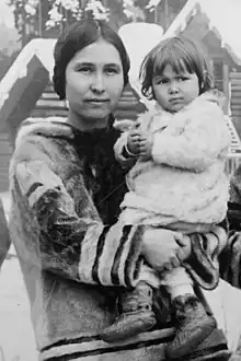 A young Inuit woman, holding a baby