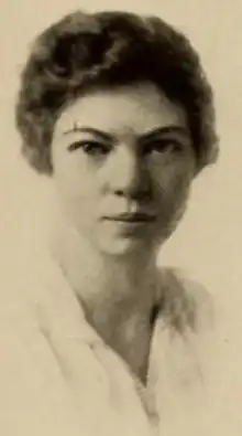 A young white woman with short dark hair, wearing a white blouse
