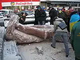 Toppled Lenin statue being broken into pieces for souvenirs