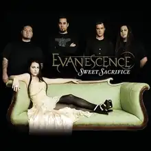 A picture showing five people in a black room. The woman in front has black hair and a yellow dress and is lying on a couch. Four men are shown behind her and all of them are wearing black T-shirts. In front of them, the word "Evanescence" is written with yellow letters. Another word "Sweet Sacrifice" can be also seen which is written in white letters.