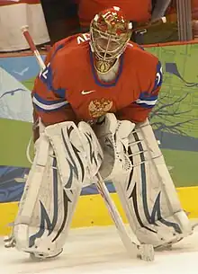 Evgeni Nabokov is bent over skating on the ice. He is wearing a red jersey and white pads.