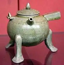 Ewer, lidded tripod with handles, used for heating certain alcoholic drinks. Stoneware with pale green (celadon) glaze. Six Dynasties, 500-580 CE. Victoria and Albert Museum, London