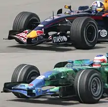 the bottom car has a white band around the circumference of its tyre while the top does not